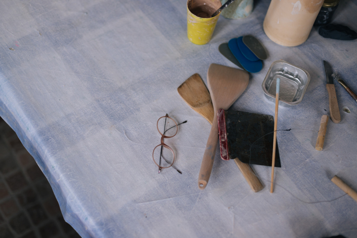 Foto zeigt Modellierwerkzeuge und Brille auf einem Tisch liegend