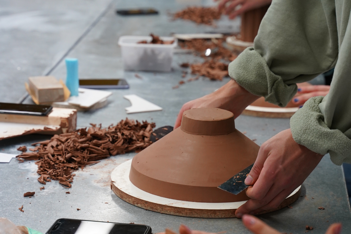 Foto zeigt Hände, die nach einem ClayModell greifen