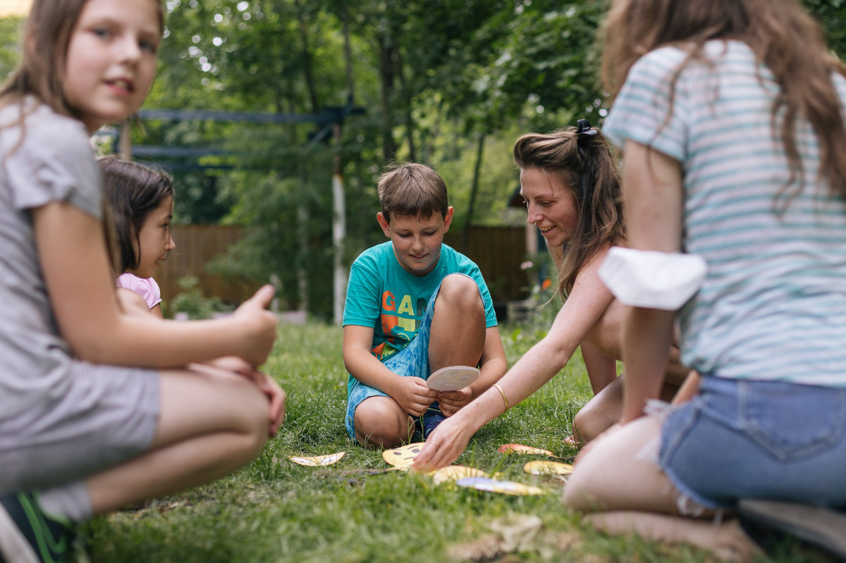 Foto zeigt, wie Maike mit Kindern im Kreis sitzt und interagiert