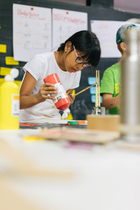 Foto zeigt Kind, das Farbe aus einer Tube drückt