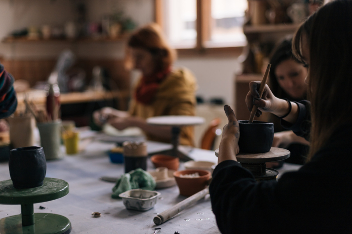 Foto zeigt Menschen in Keramikwerkstatt Gefäße modellieren – ein Einblick in den Töpferkurs