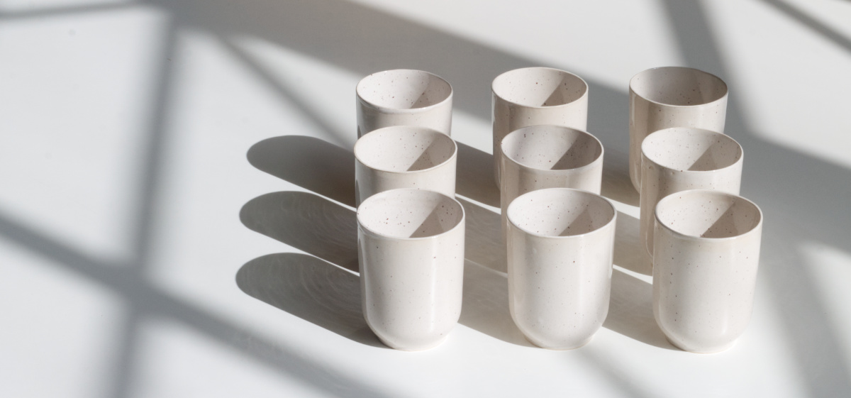 Bild zeigt neun Becher in einem Quader angeordnet mit grafischem Schattenwurf umgeben