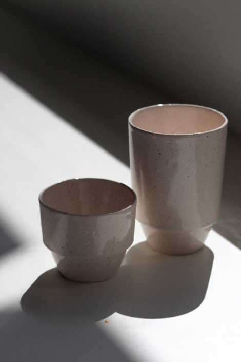 Zwei unterschiedliche hohe Becher in dramatischem, stimmungsvollem Licht