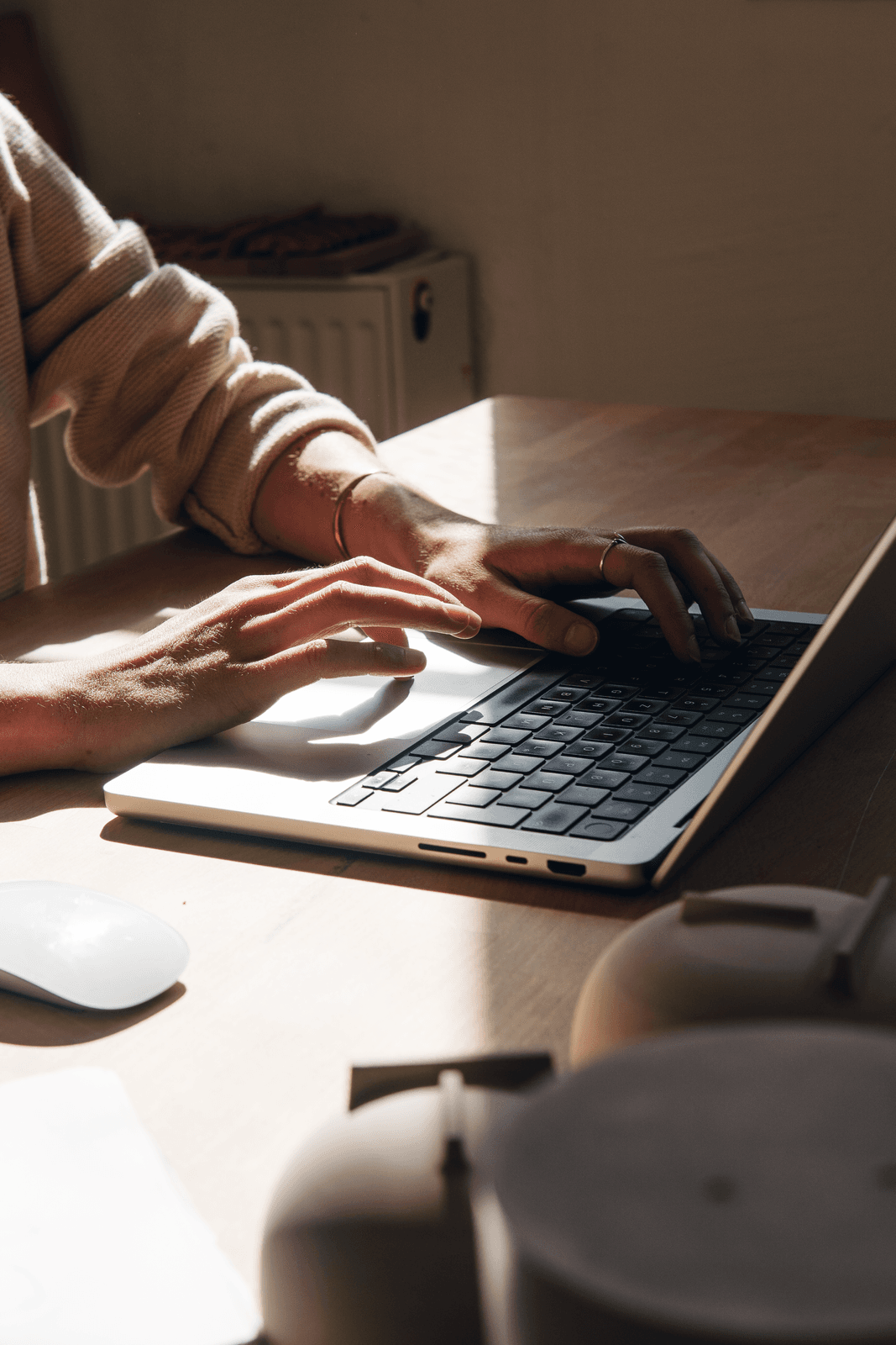 Foto zeigt Hände auf einer Tastatur, Sonne wirft einen starken Schatten auf die Hände