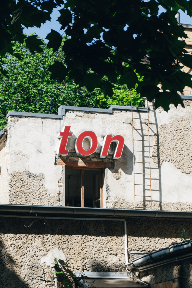 Blick auf ein Fenster, über der eine Leuchtreklame mit dem Wort "Ton" hängt