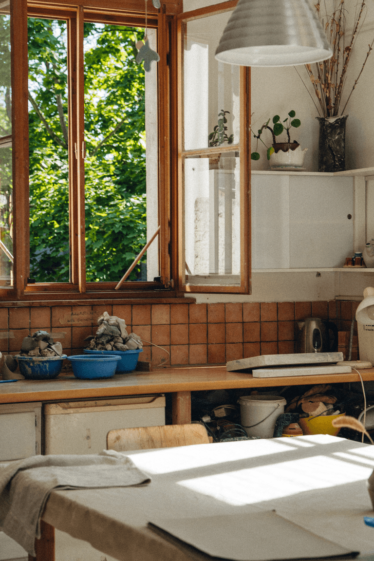 Blick auf ein offenes Fenster einer Werkstatt. Licht fällt in den Raum