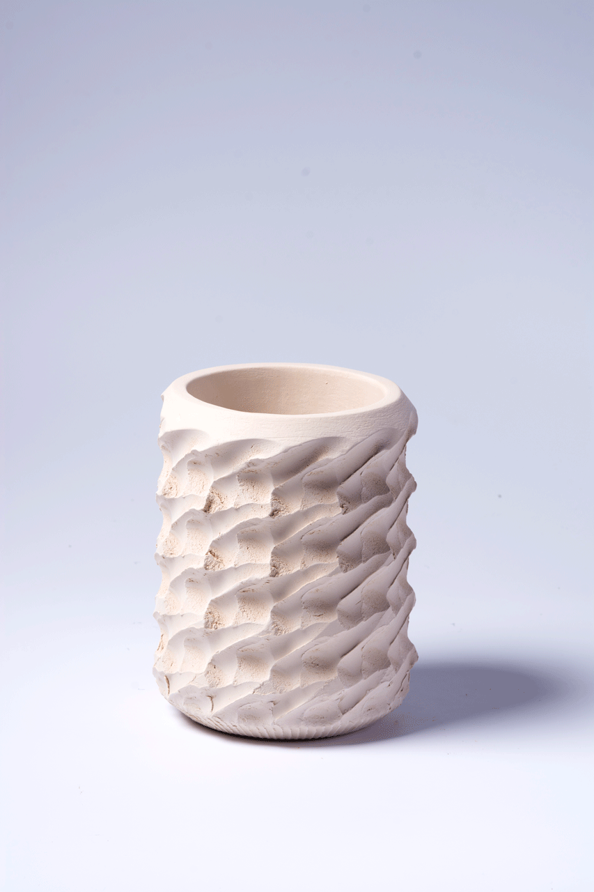 Bild zeigt eine kleine Vase, die eine sehr regelmässige Struktur auf der Außenfläche hat