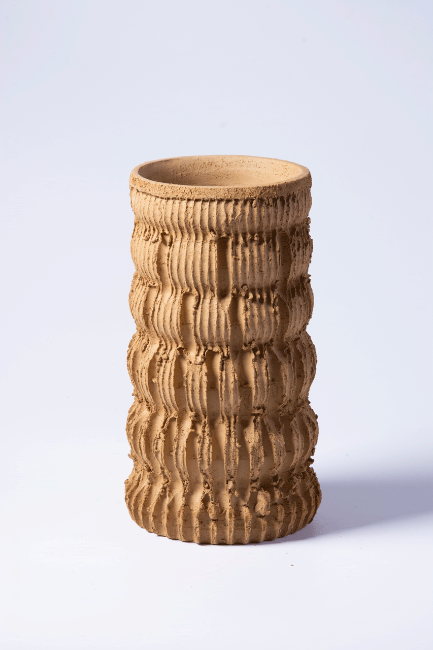 Bild zeigt eine vertikal strukturierte, linierte Vase aus rotem Ton