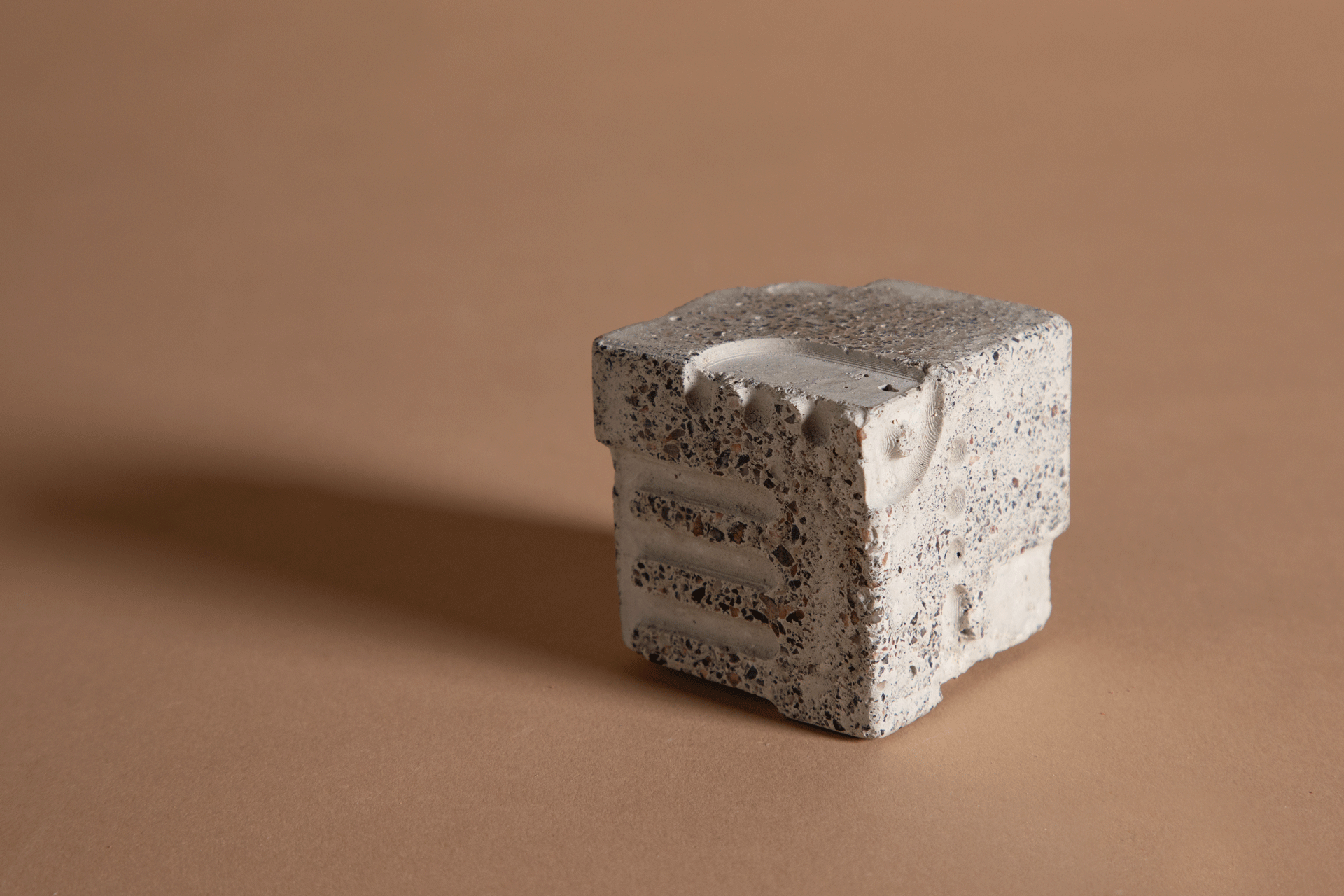 wesen3 Bild zeigt einen grauen Geoploymer-Würfel aus recyceltem Beton